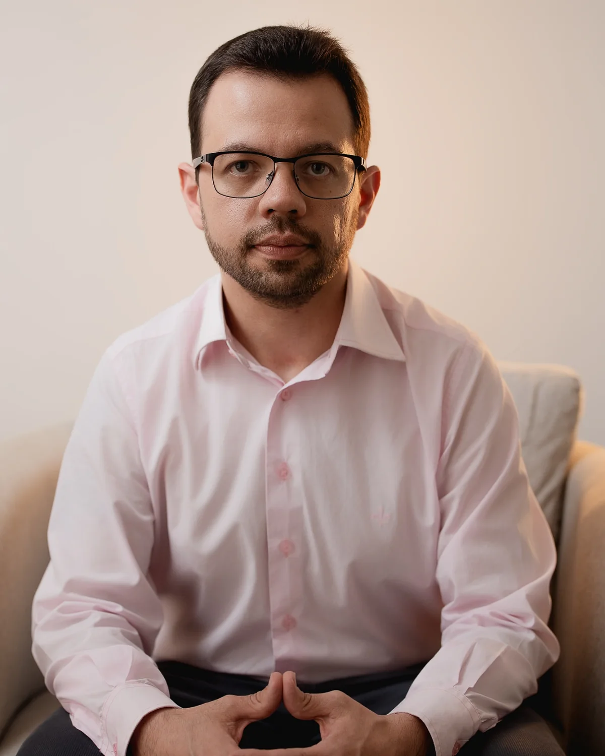Dr. Edek sentado em uma poltrona, olhando para a câmera